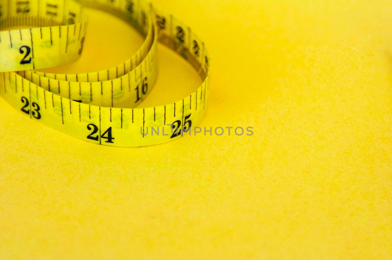 Yellow measuring tape with customizable space for text or ideas. Copy space and weight loss concept.