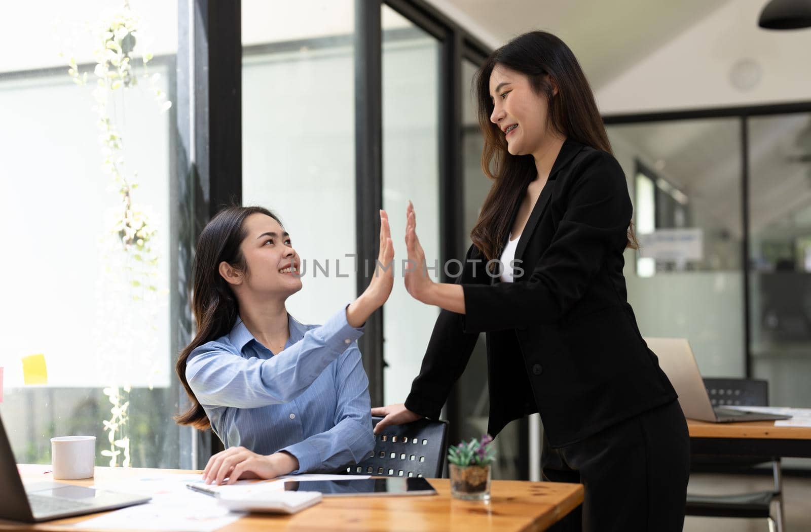 Group of Young Asian business team creative businesspeople coworker in office Happy to be successful partnership teamwork celebrating achievement and success concept