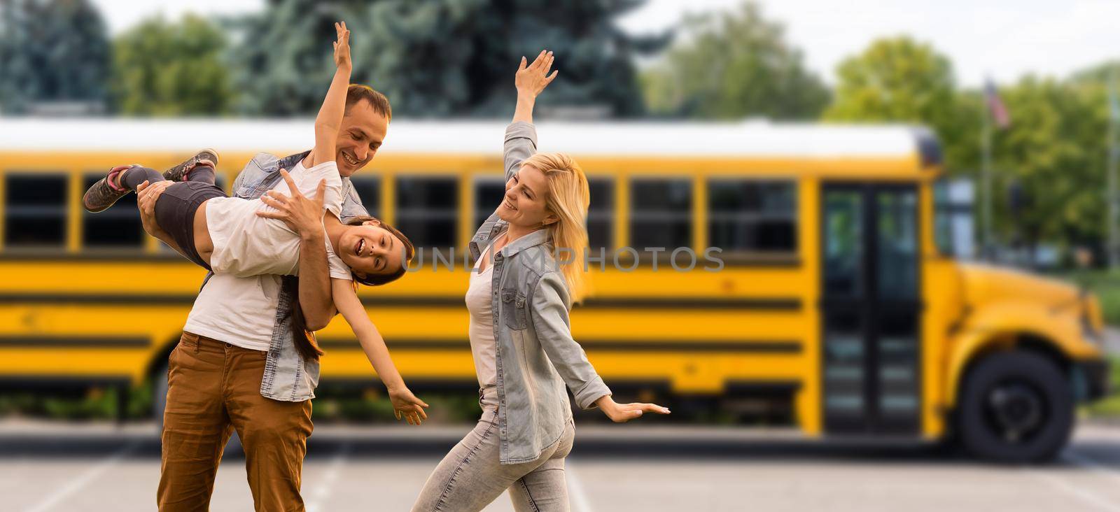 family together by the school bus.