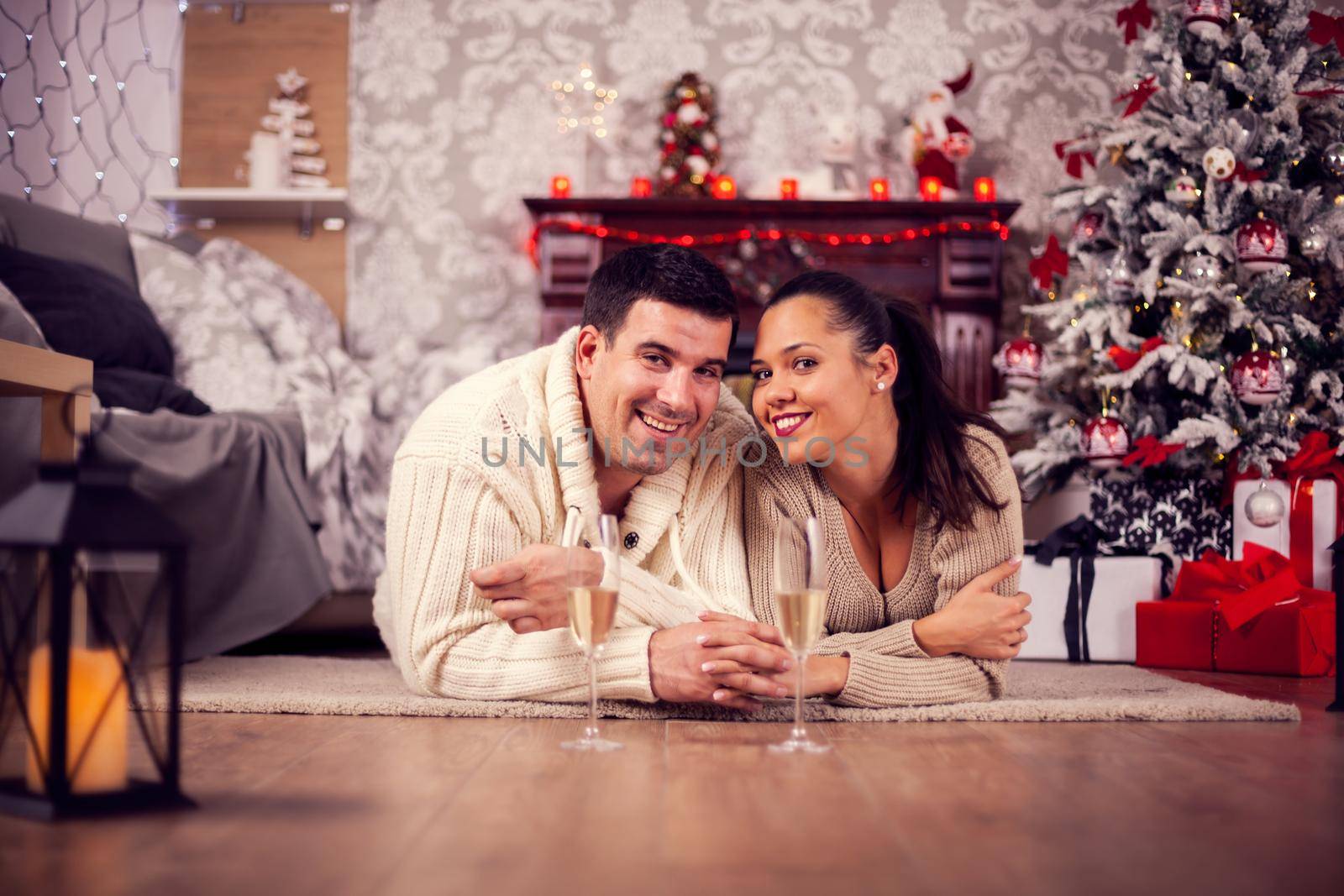 Beautiful husband and wife celebrating christmas looking into the camera by DCStudio
