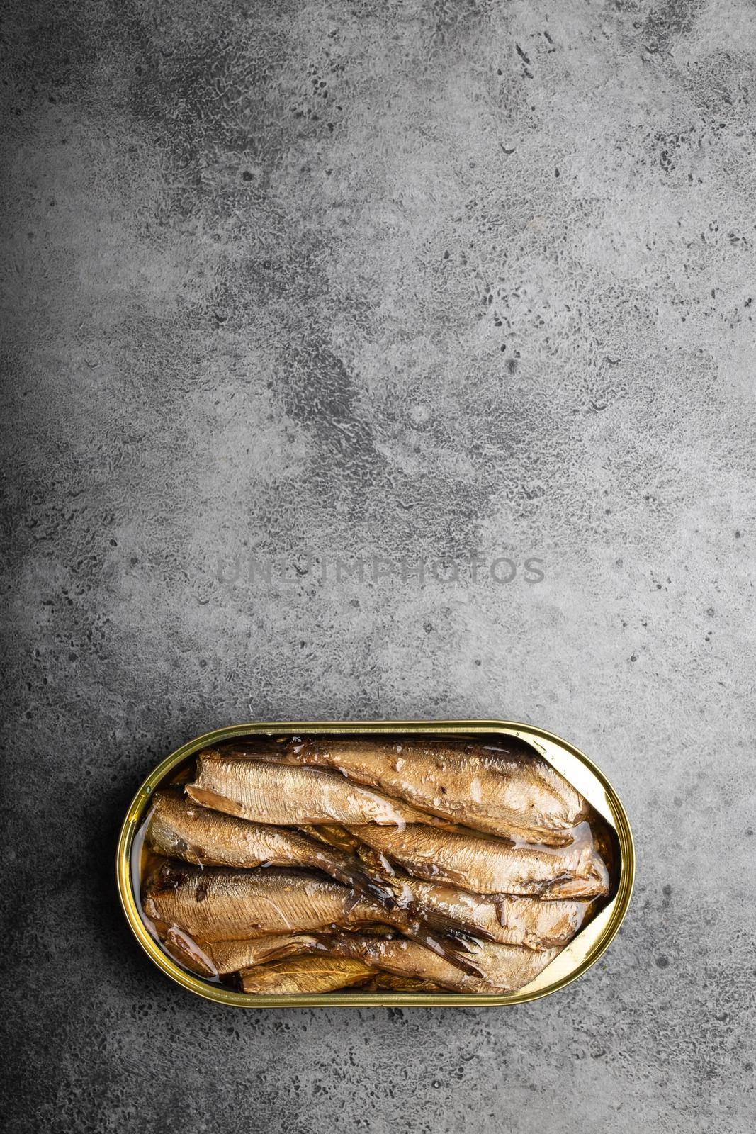 Close up and top view of smoked canned sardine in a tin over gray background, space for text. Tinned fish as a convenient, fast, healthy food and source of omega-3 fatty acids, protein and vitamin D