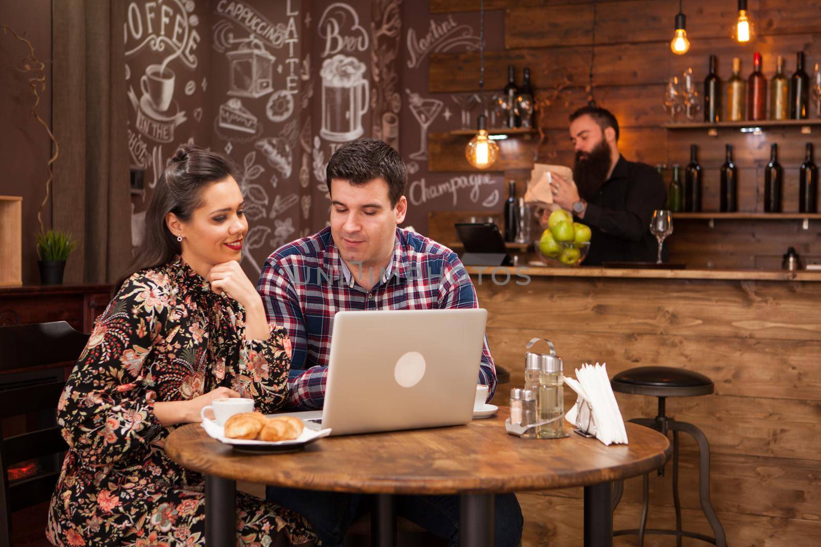 Attractive couple at a business meeting in the restaurant disucssing working moments at lunch time. Hipster pub.