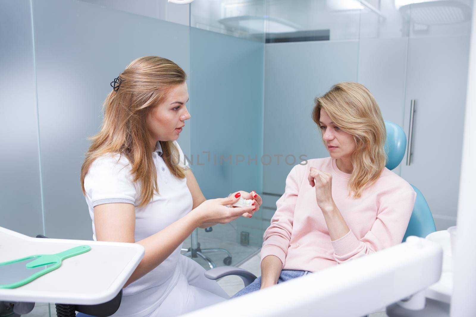 Female dentist educating her patient on dental hygiene