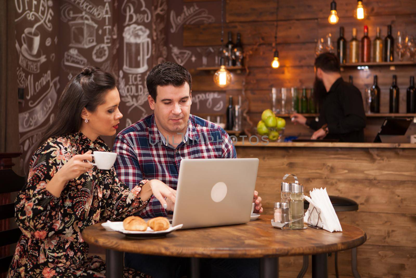 Attractive couple at a business meeting in the restaurant disucssing working moments at lunch time. Hipster pub.