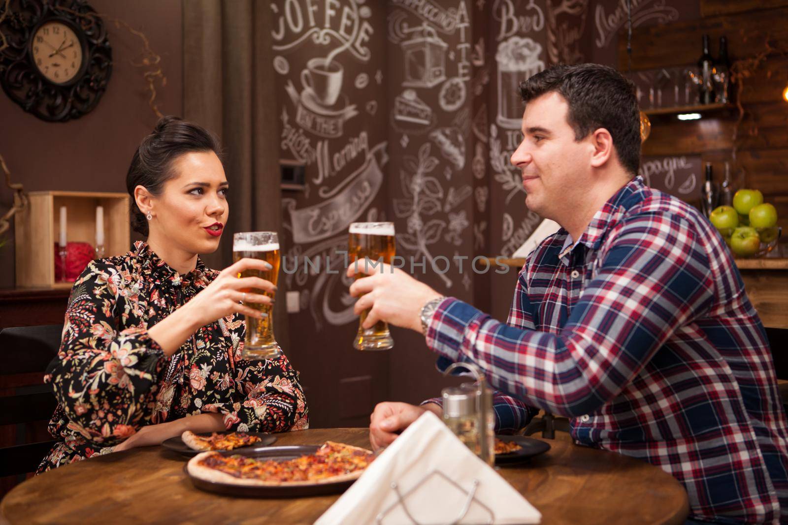 Lovely couple in new pub enjoying their beer. Hipster pub.