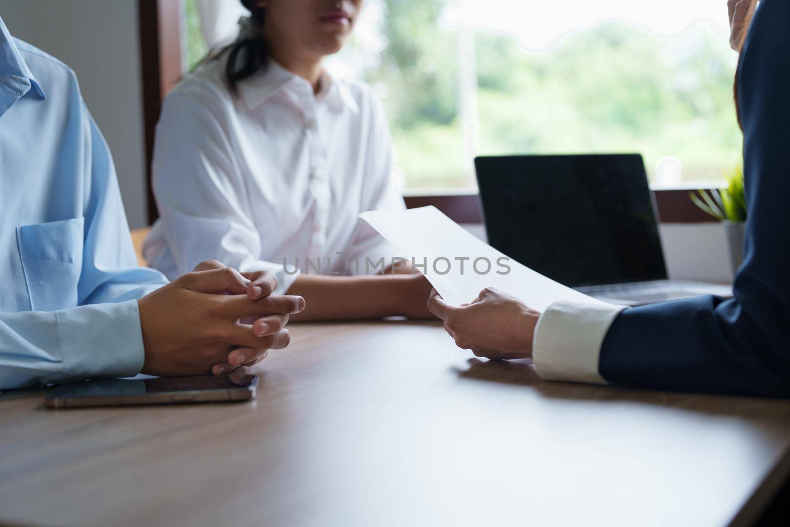 Couples consult with a representative to plan an insurance contract.