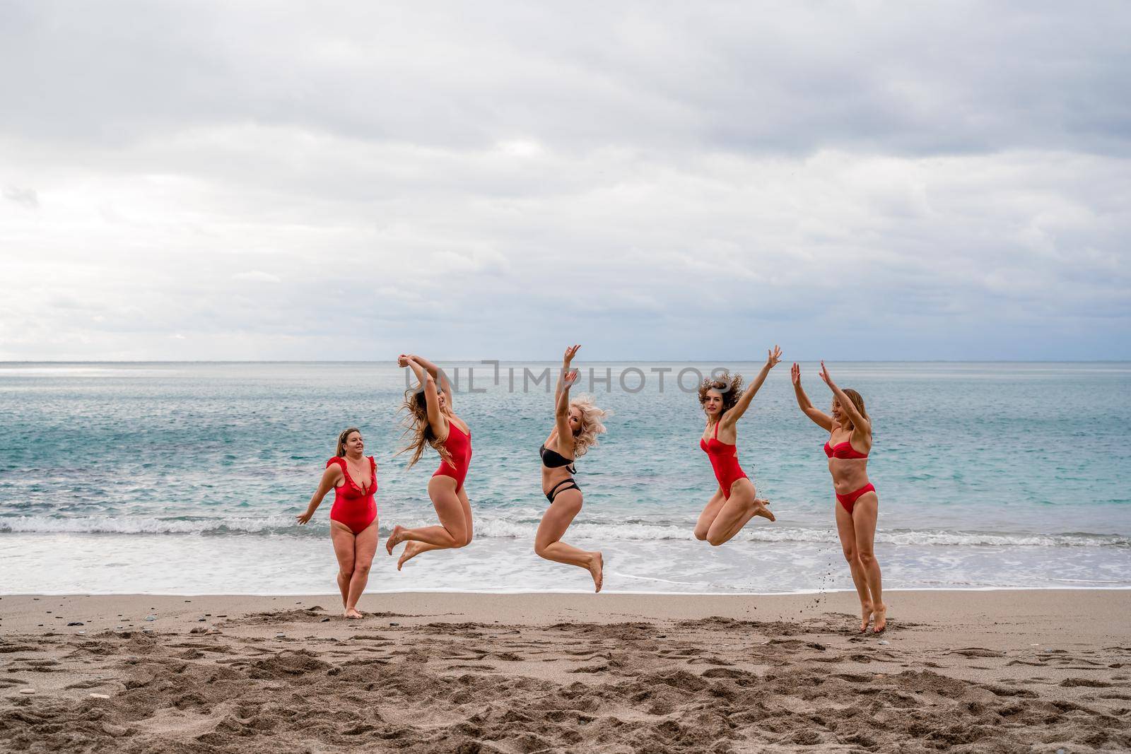 Big happy family or group of five friends is having fun against sunset beach. Beach holidays concept