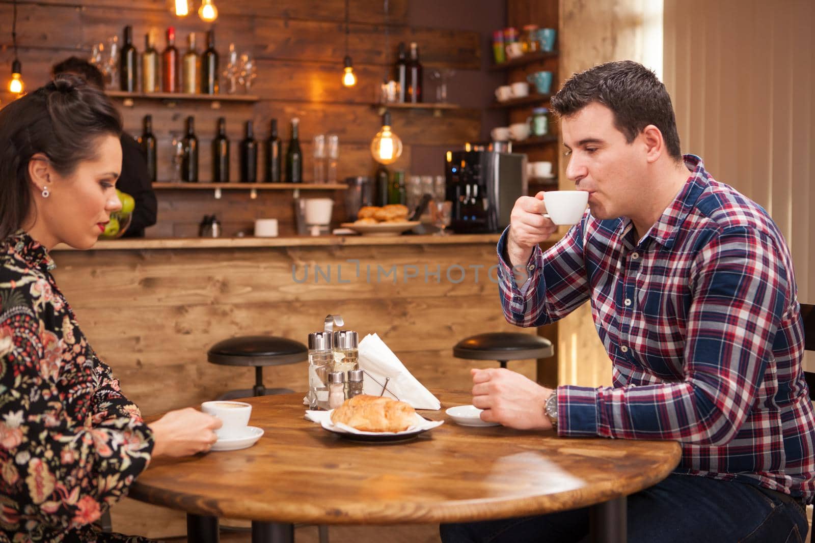 Young couple talking about the future in a cozy vintage pub. Hipster pub.