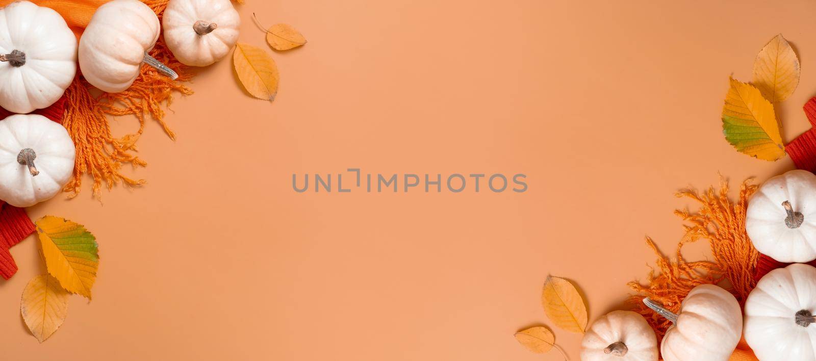 Autumn banner flat lay composition with pumpkins and fallen leaves and sweater with space for text. by ssvimaliss
