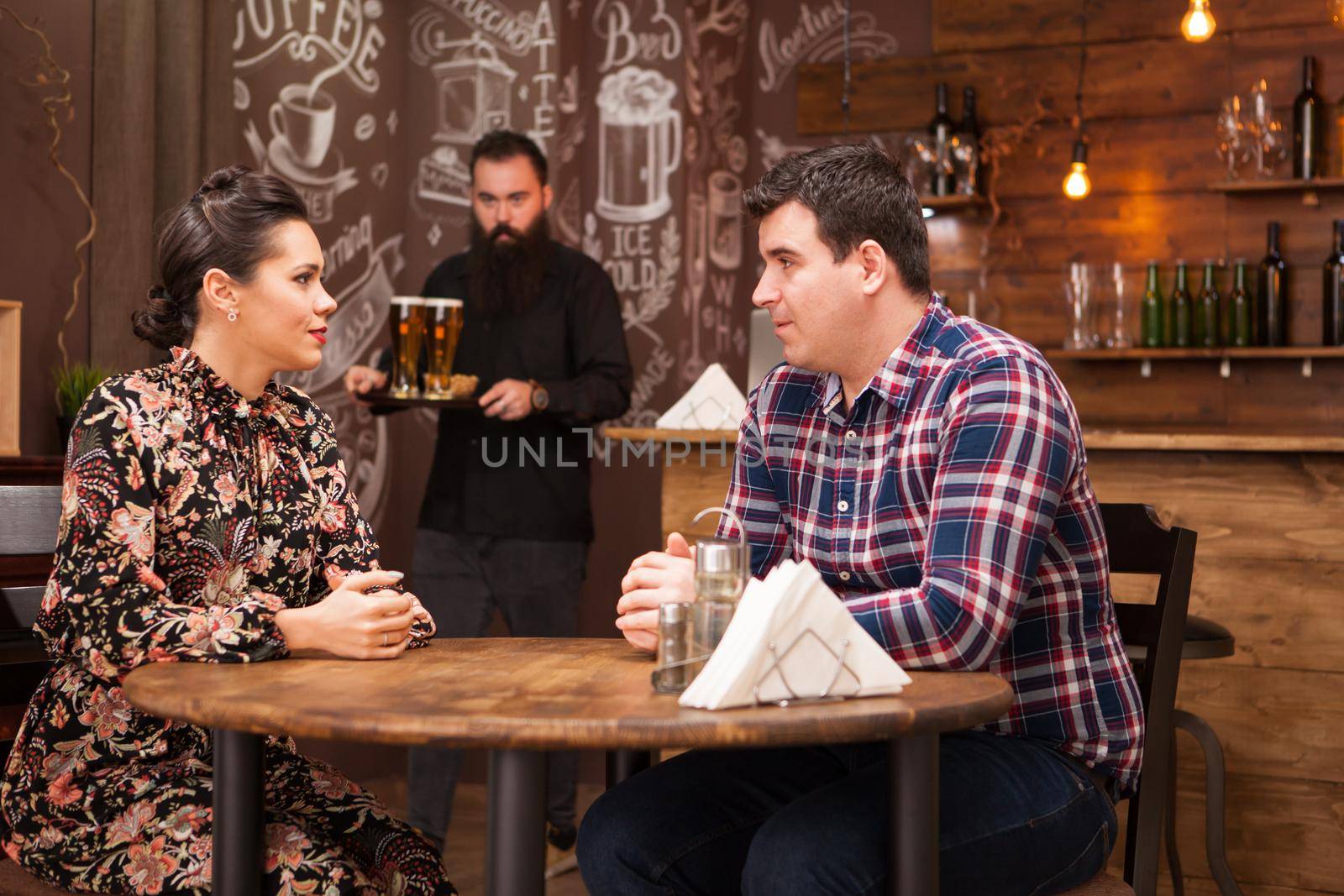 Young couple sitting in a restaurant talking and having a good time.