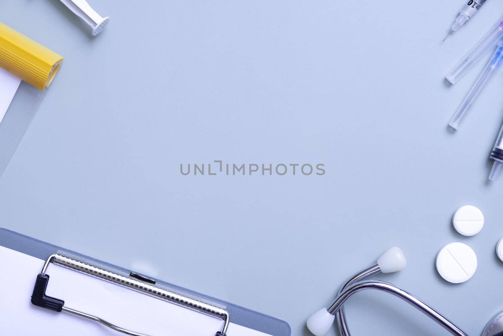 Pills, stethoscope, syringes and tablet at doctor's workplace with copy space.