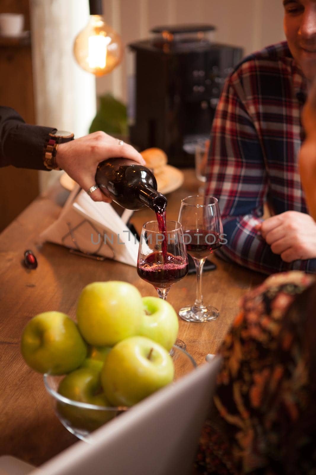 Bartender pouring red wine from a bottle in a wine glass. Hipster pub.