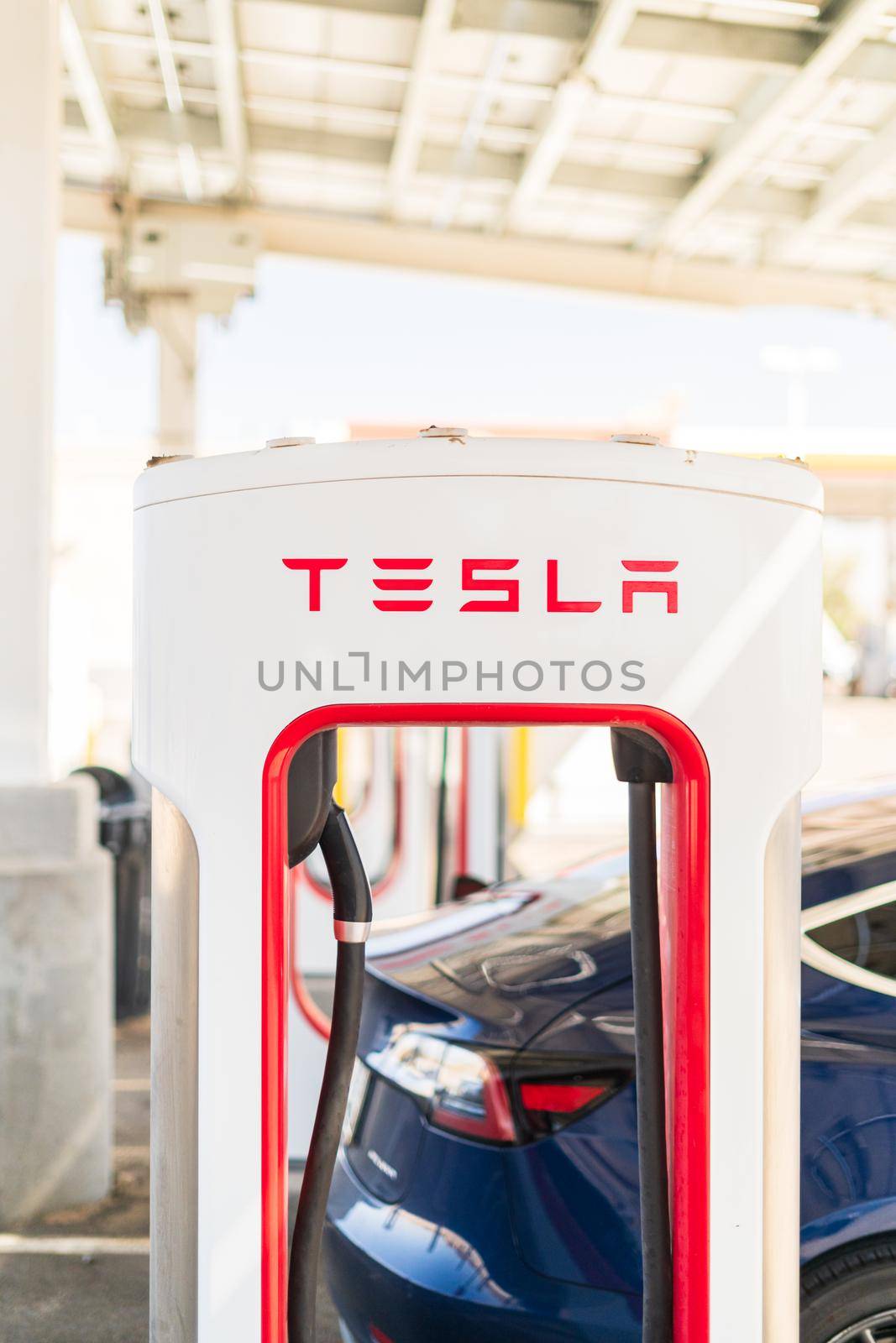 Baker, California, USA-October 12, 2021 - Tesla supercharging station during the day.