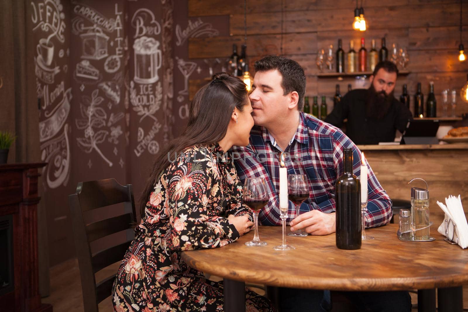 Happy couple drinking wine when having date in restaurant. by DCStudio