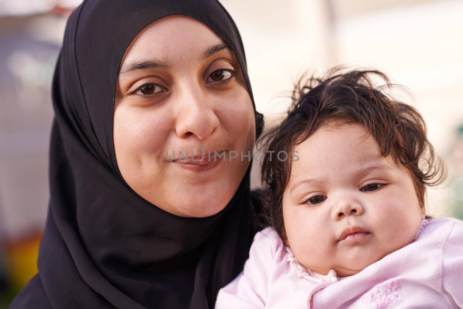 She takes after her dad. a muslim mother and her little baby girl. by YuriArcurs
