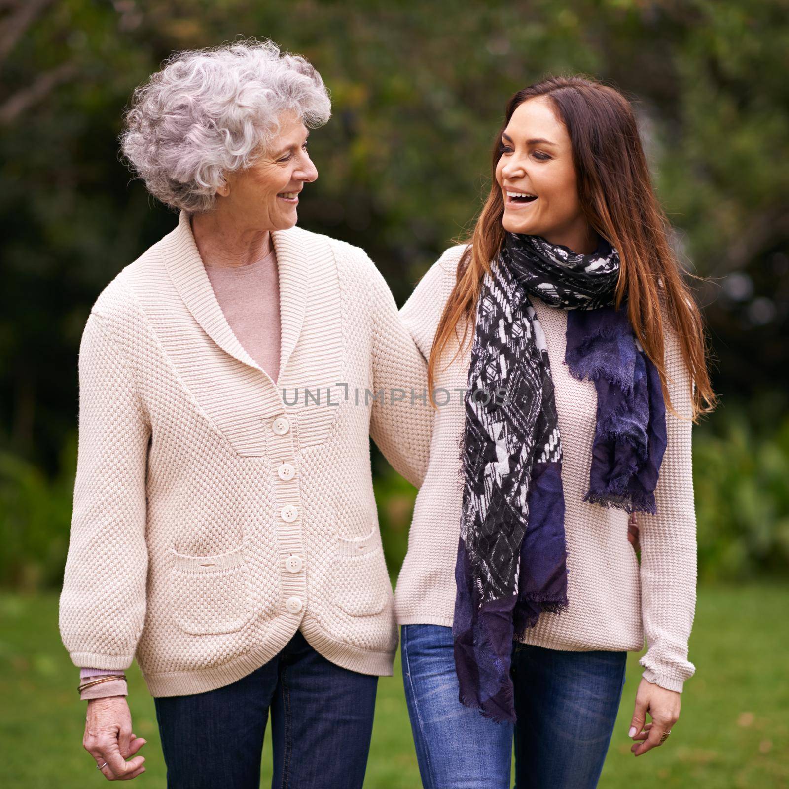 Having a great time with her mom. an attractive woman spending time with her senior mother outdoors. by YuriArcurs