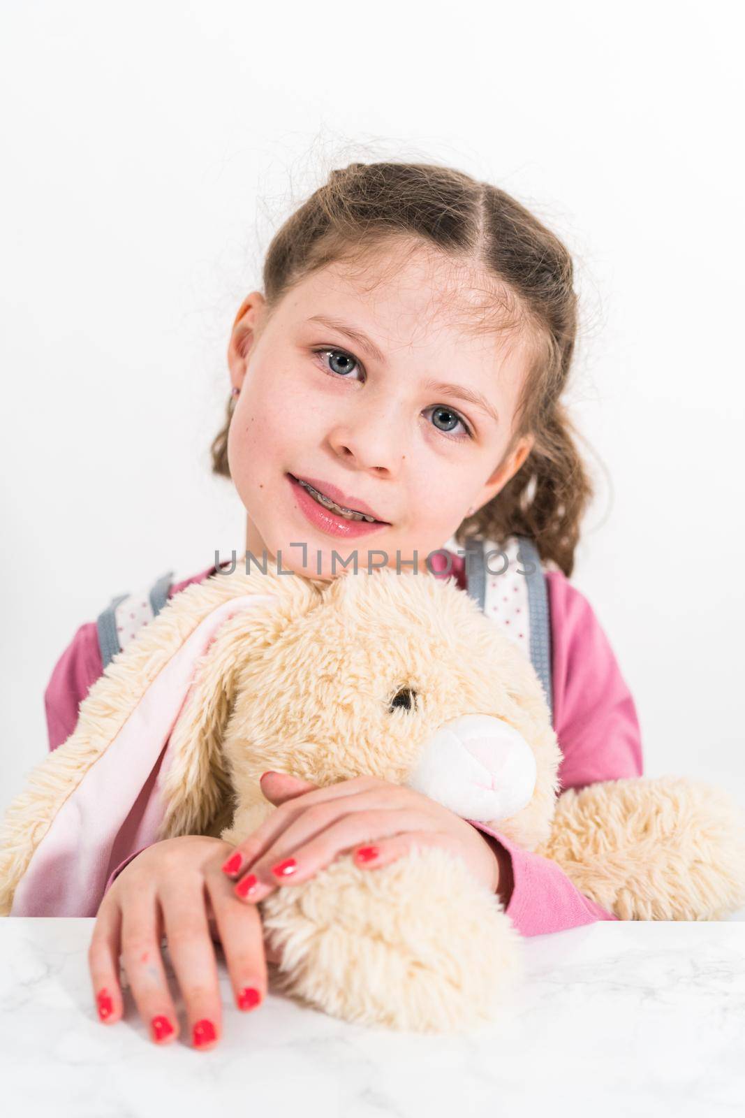 Easter egg coloring. Little girl hugging her big stuffed bunny.