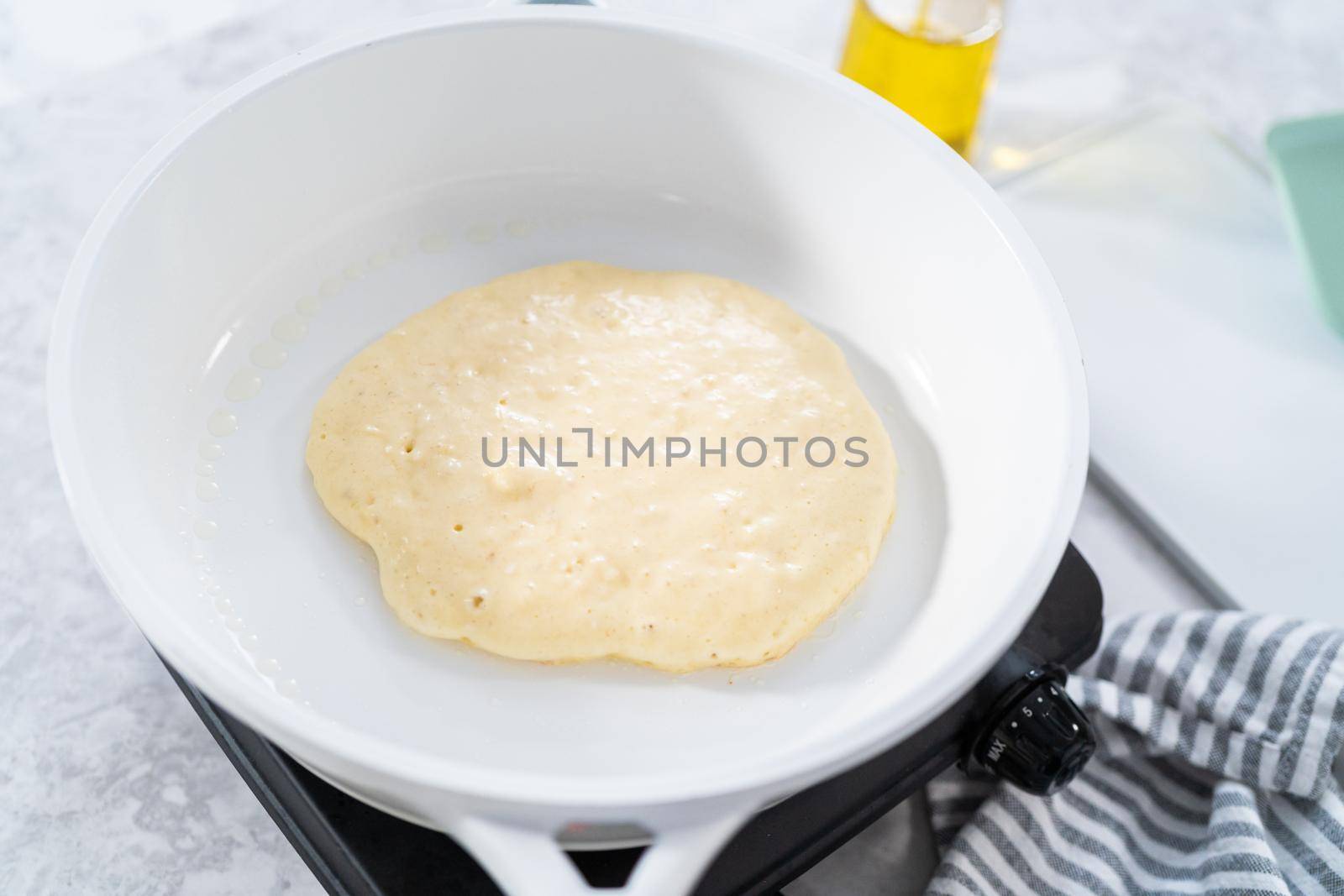 Trying coconut banana pancakes on a nonstick white frying pan.