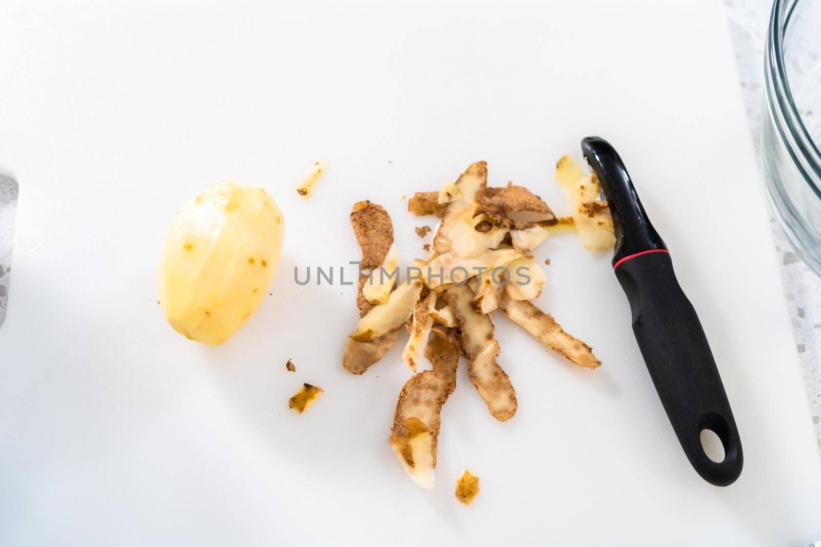 Peeling and cutting Russet potatoes to make potato salad.