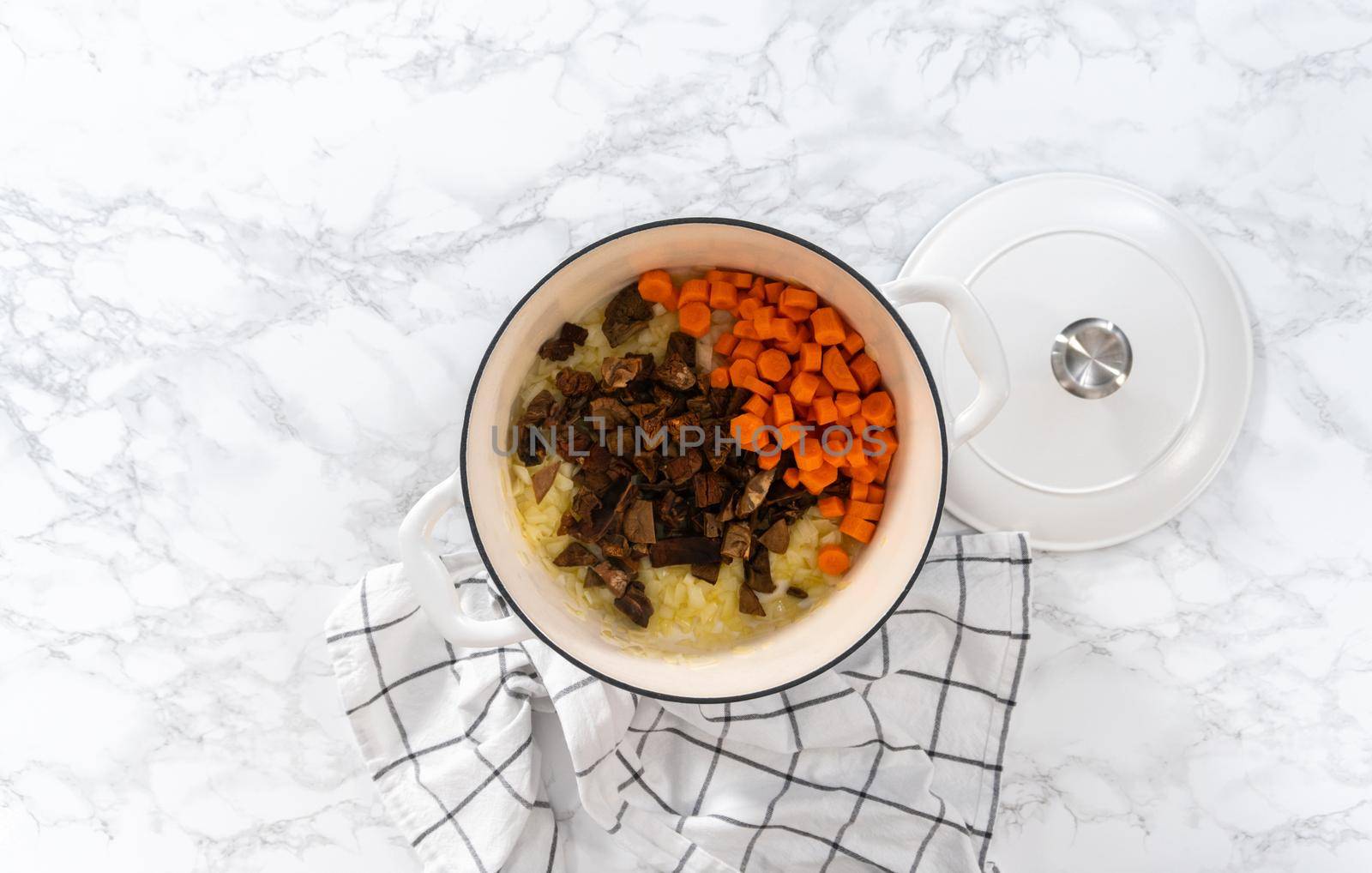 Flat lay. Cooking creamy wild mushroom soup made in an enameled dutch oven.