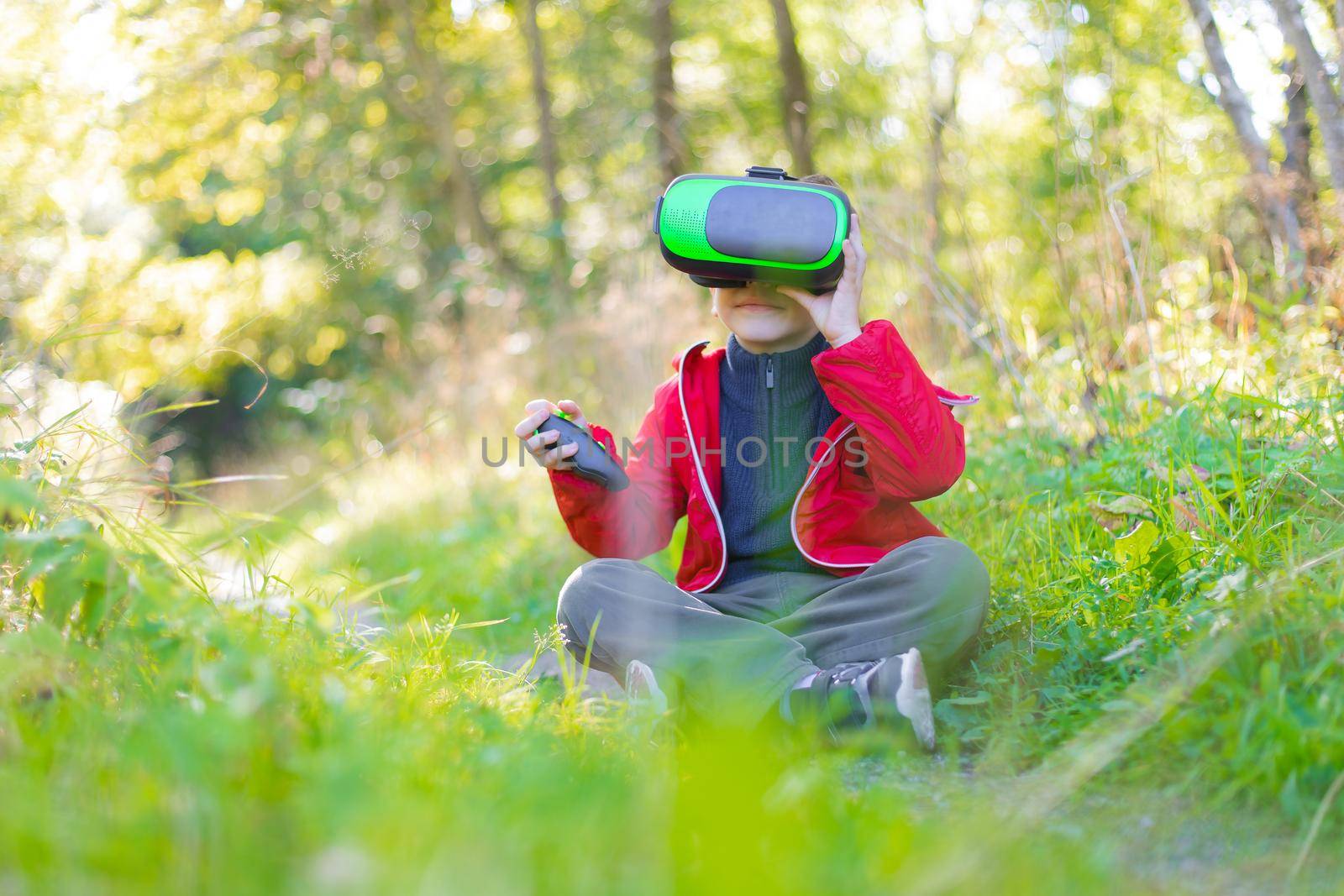 A boy in virtual reality glasses on the street . Modern children . 3D glasses. Modern technologies. Virtual games
