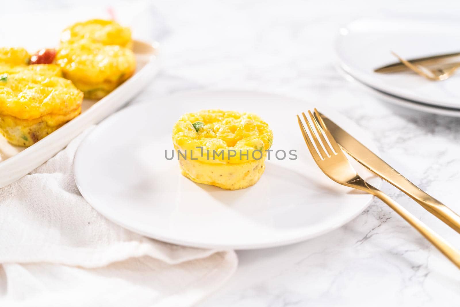 Bacon and cheese egg muffin on a white plate.