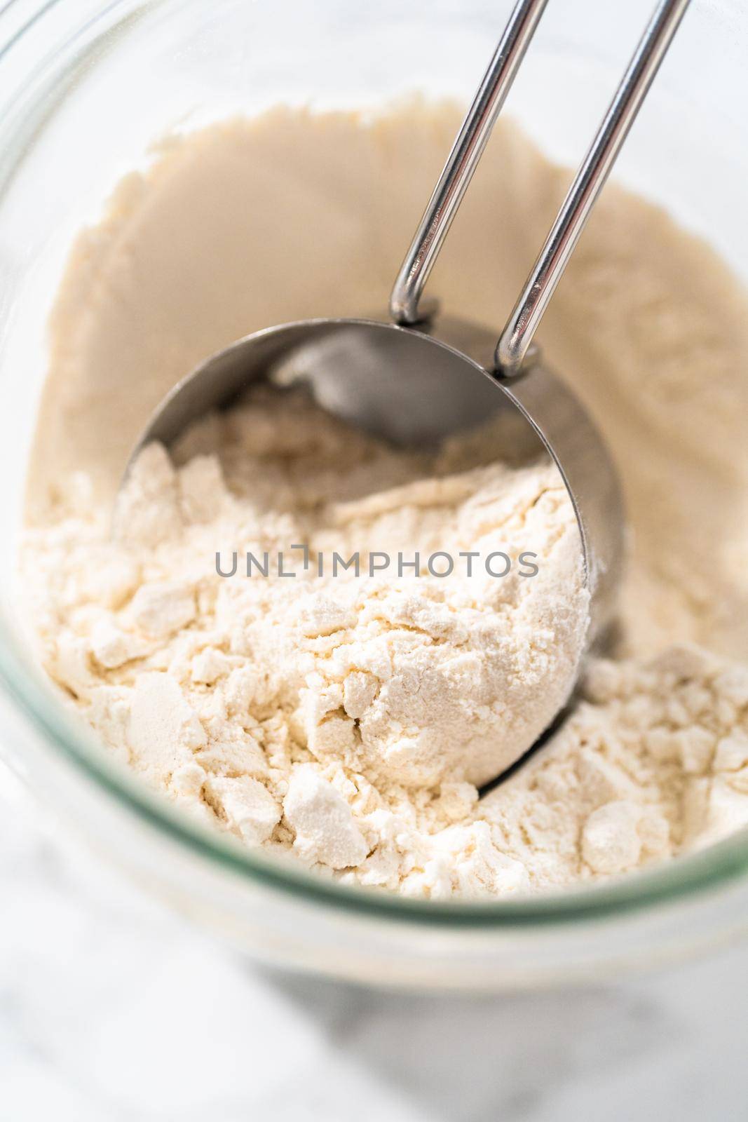 Measuring cup inside glass jar filled with all-purpose flour.