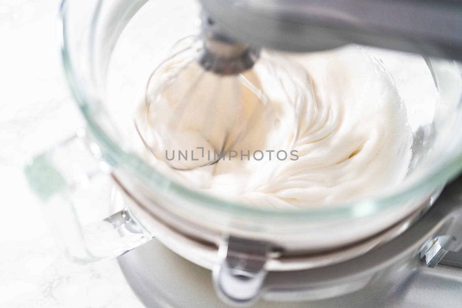 Mixing ingredients in kitchen electric mixer to bake meringue cookies.