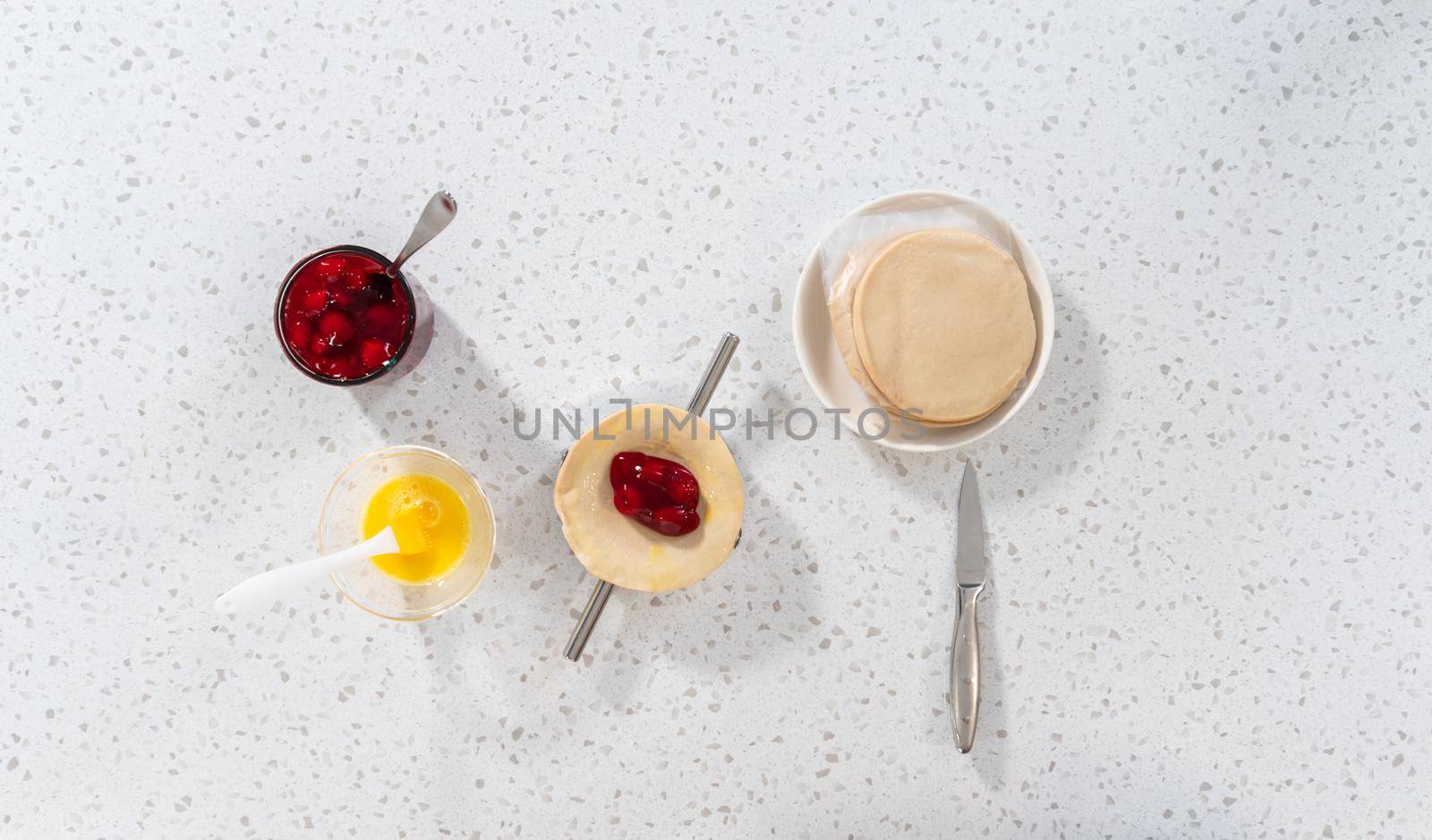 Flat lay. Filling empanada dough with cherry pie filling to make sweet cherry empanadas in the air fryer.