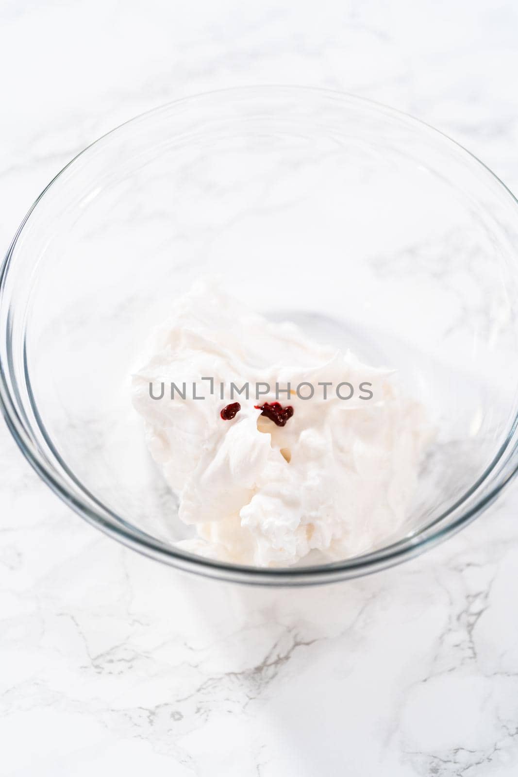 Mixing food coloring into the meringue to bake meringue cookies.