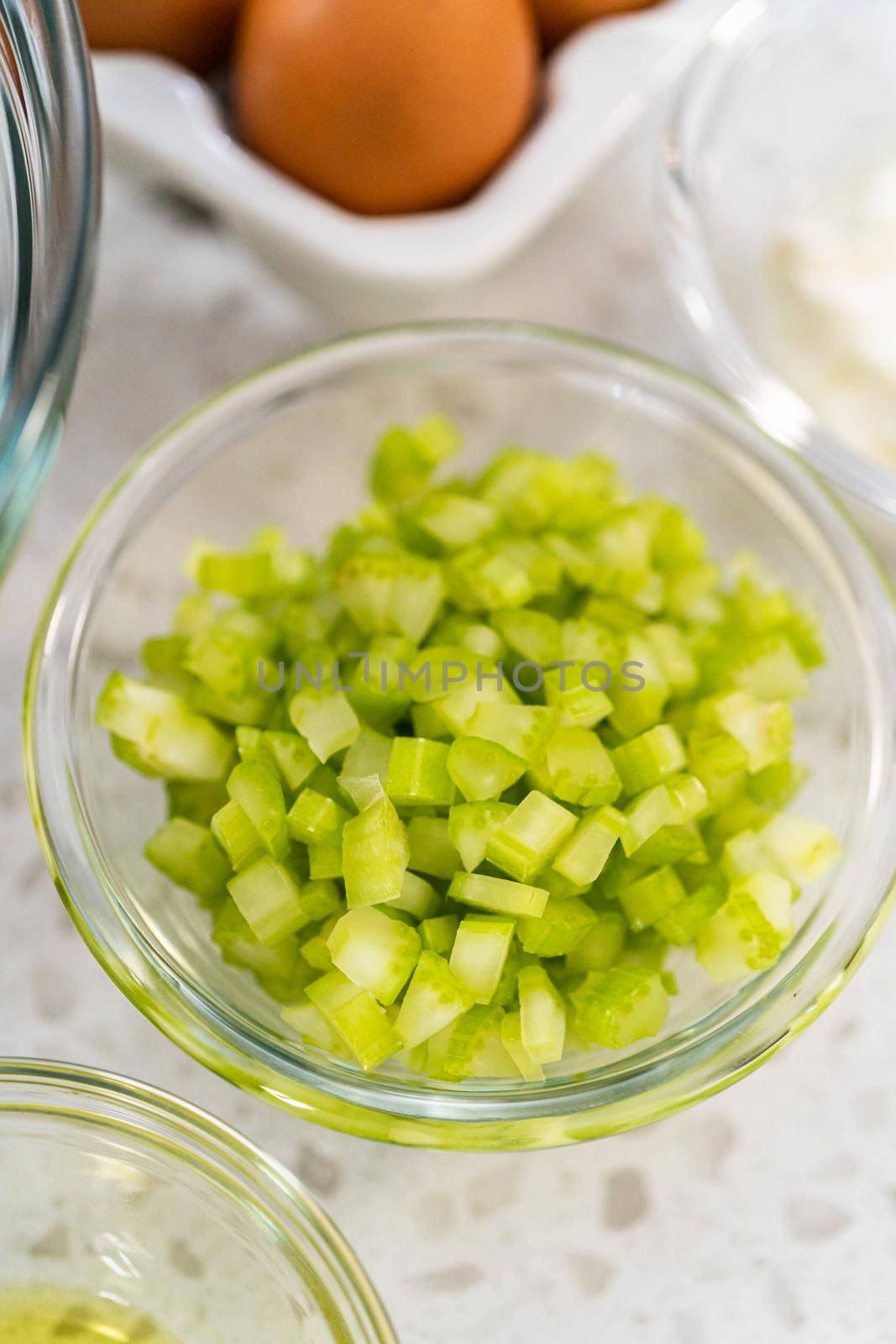 Measured ingredients in glass mixing bowls to make potato salad.