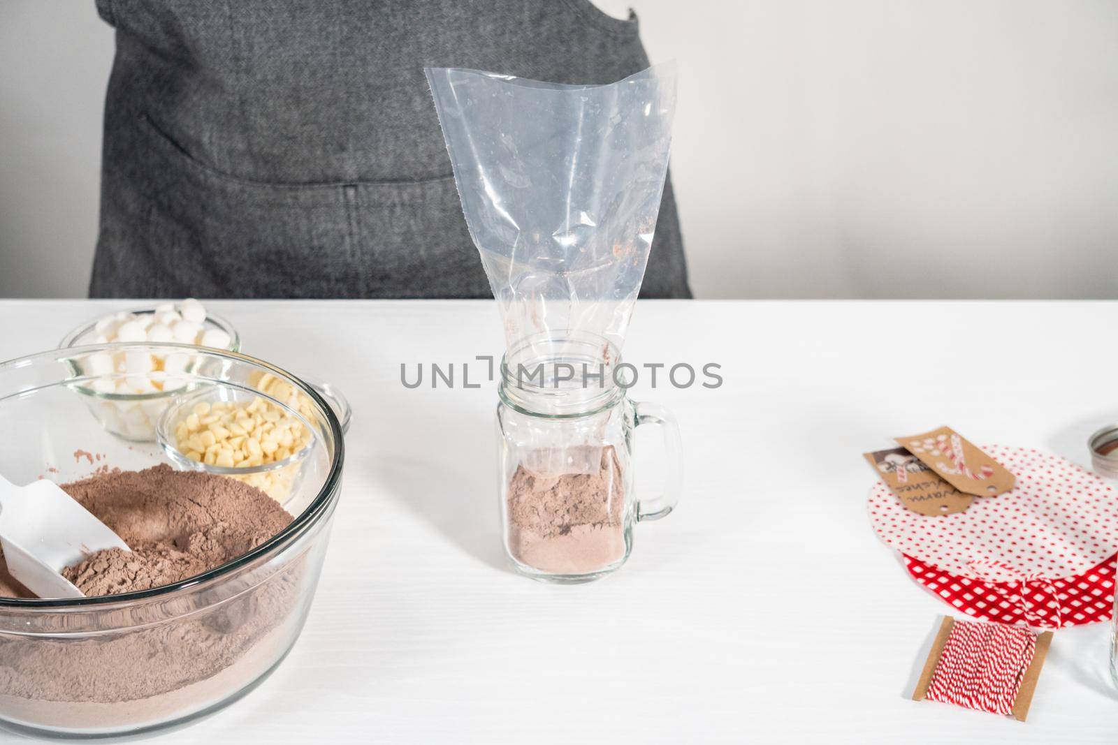 Making homemade hot chocolate mix in drinking mason jar for Christmas food gift.