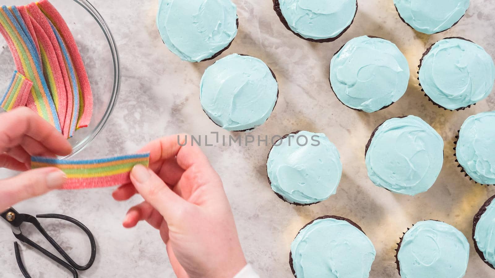 Flat lay. Step by step. Decorating chocolate cupcakes with buttercream frosting and rainbow candy.