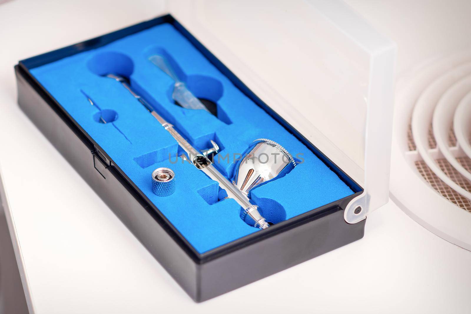 Close up of new clean airbrush tool in the blue box