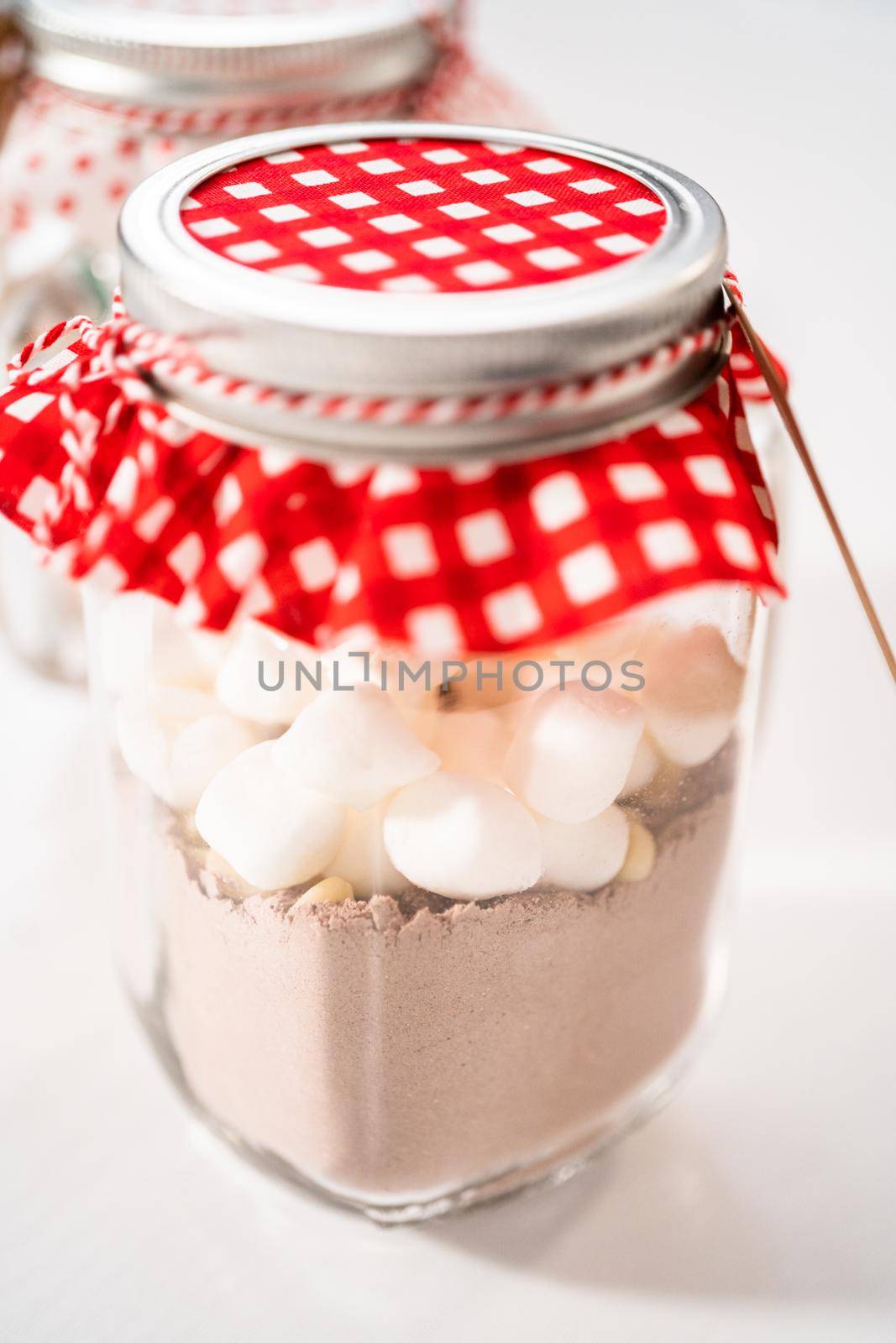 Making homemade hot chocolate mix in drinking mason jar for Christmas food gift.