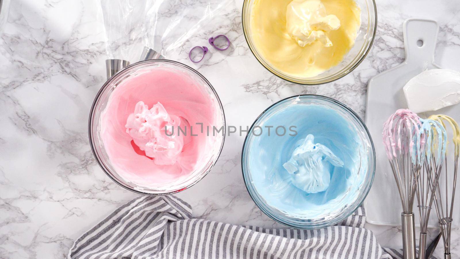 Step by step. Flat lay. Mixing food coloring into the meringue to bake unicorn meringue cookies.