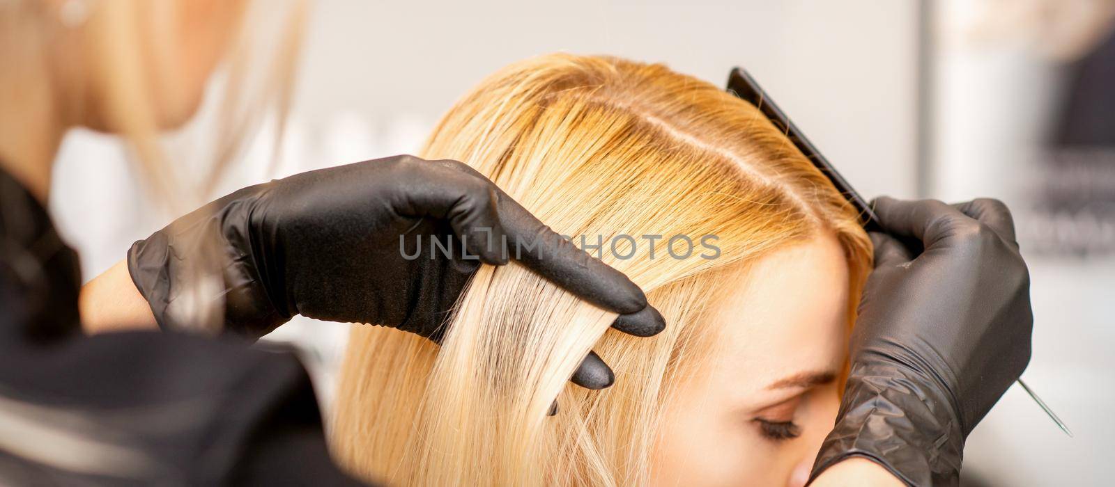 A hairdresser is combing female hairstyling in a hairdressing beauty salon