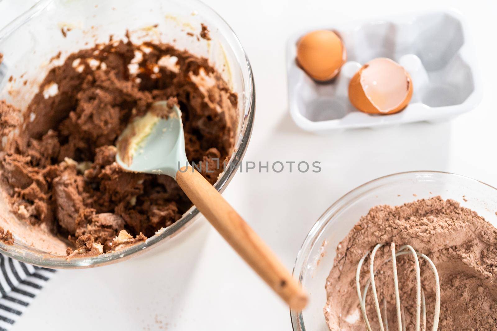 Mixing ingredients in a glass mixing bowl to bake chocolate cookies.