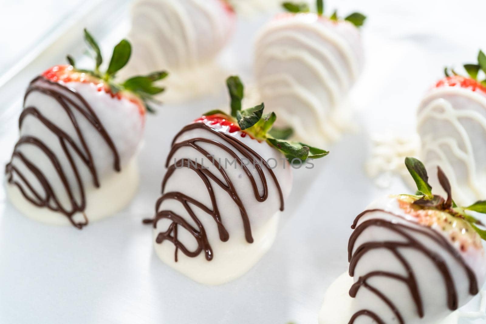 Organic strawberries dipped in chocolate drying on a parchment paper.