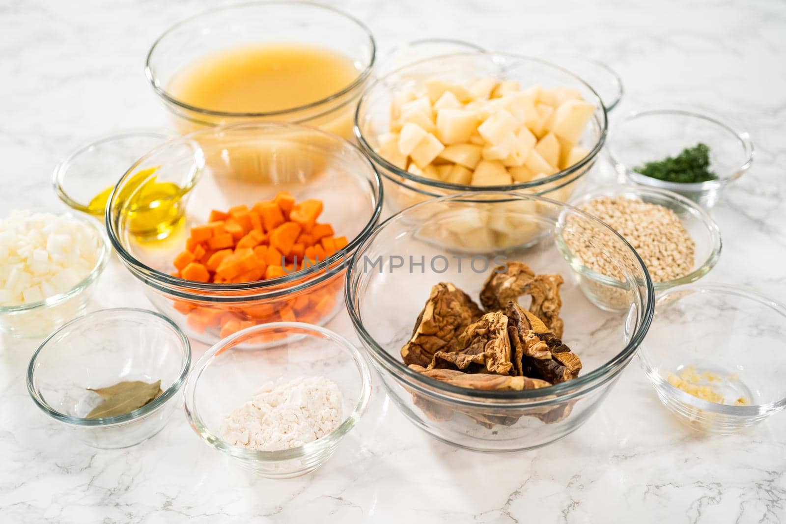 Measured ingredients in a glass mixing bowl to prepare creamy wild mushroom soup.