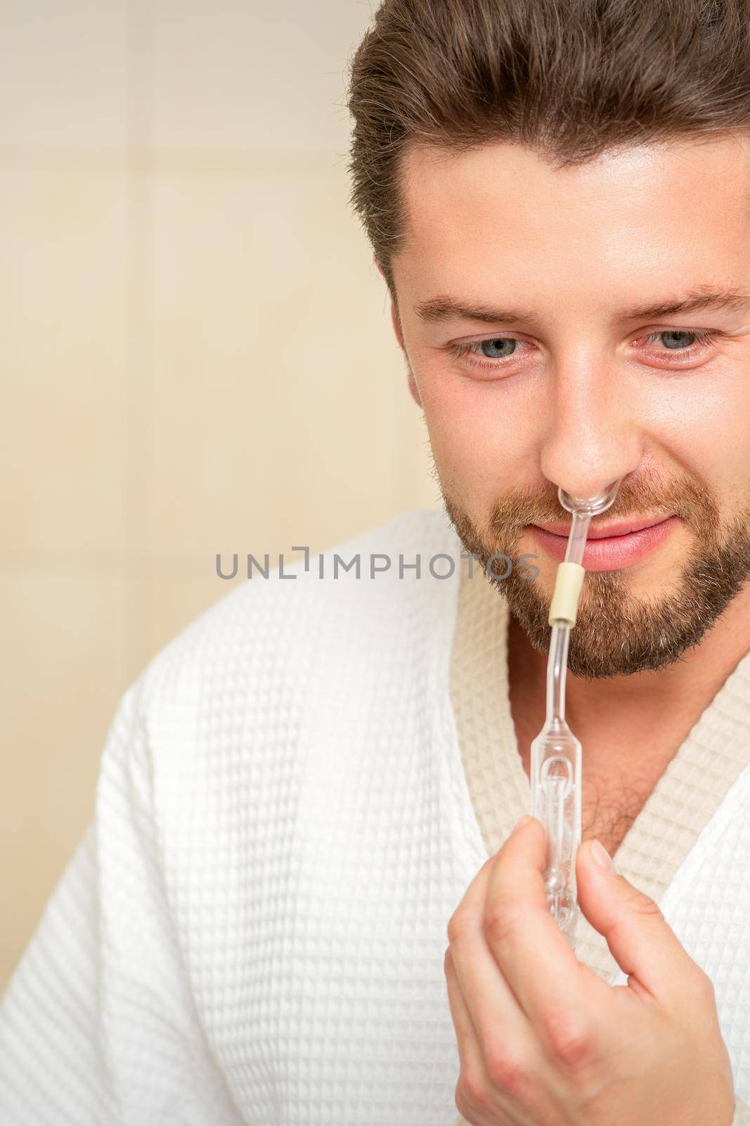 Young caucasian man receiving nasal inhalation Maholda with essential oil in the nose at a hospital