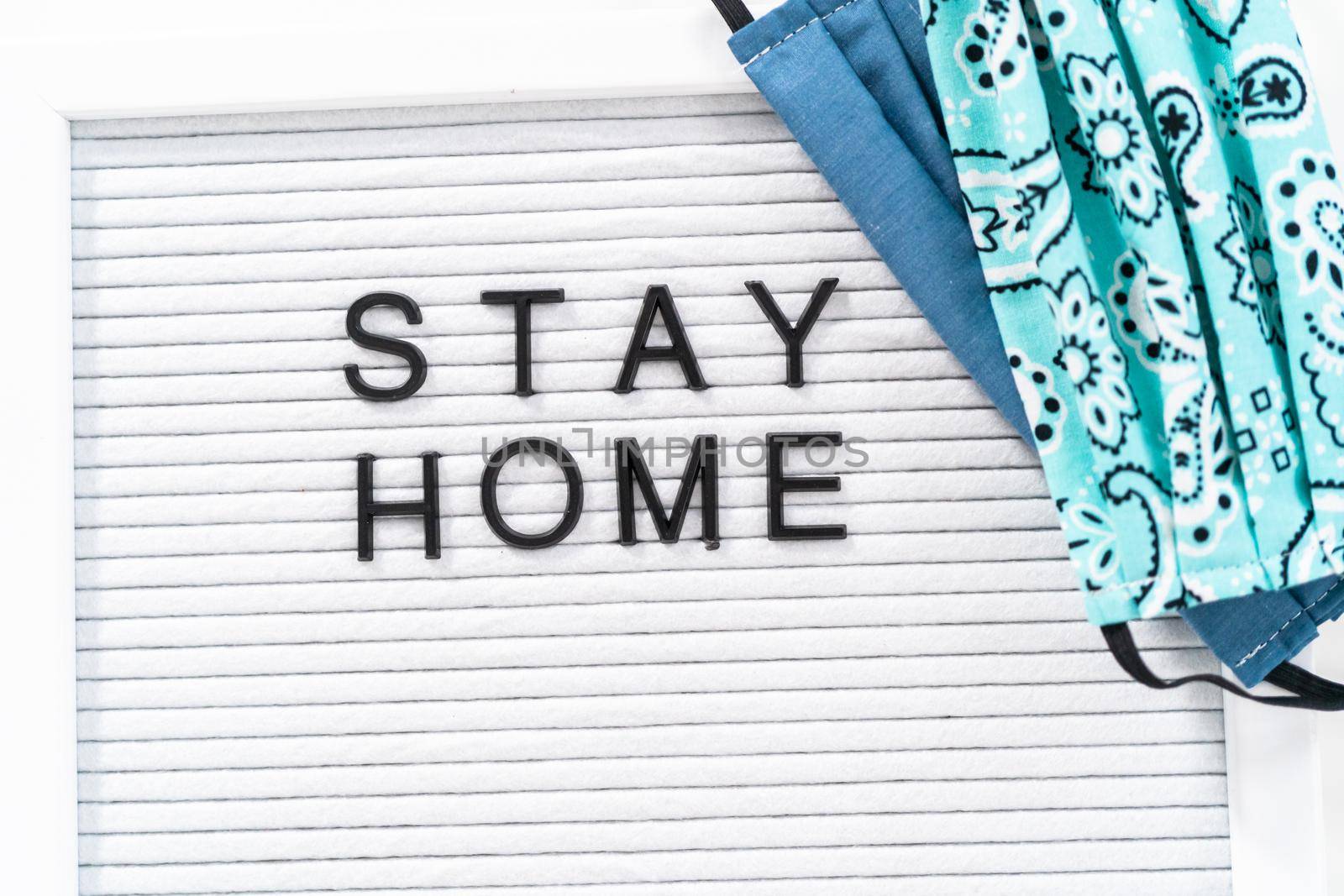 STAY HOME sign on message board with a homemade face mask.