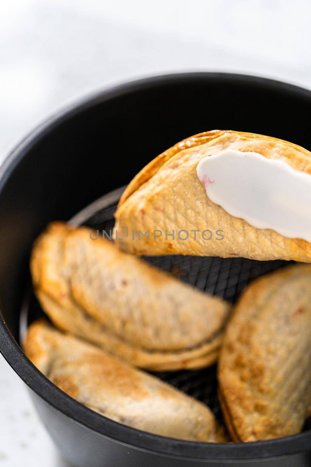 Frying sweet cherry empanadas in the air fryer.
