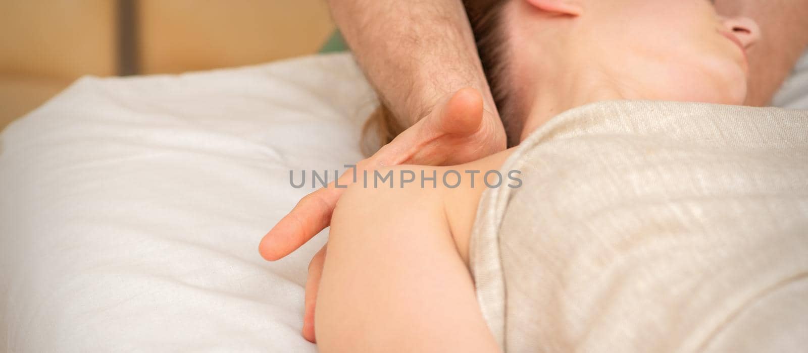 Young caucasian woman having a massage on the shoulder in spa salon