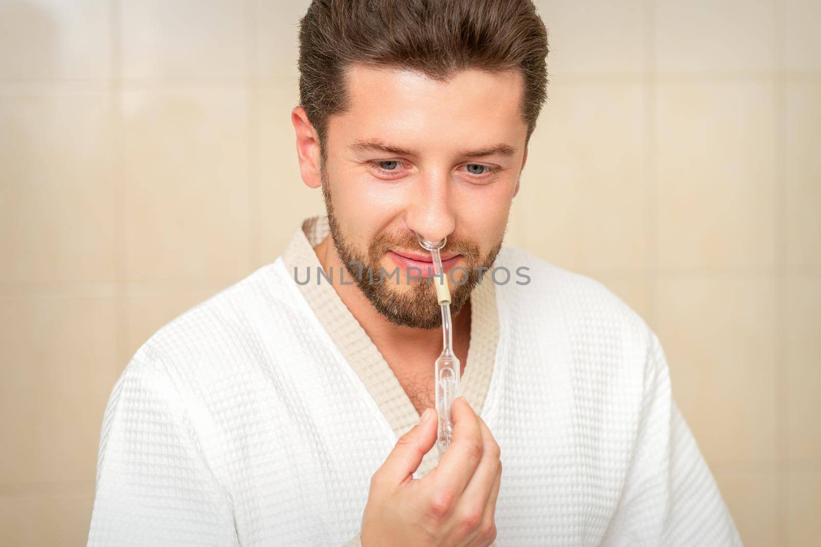 Young caucasian man receiving nasal inhalation Maholda with essential oil in the nose at a hospital