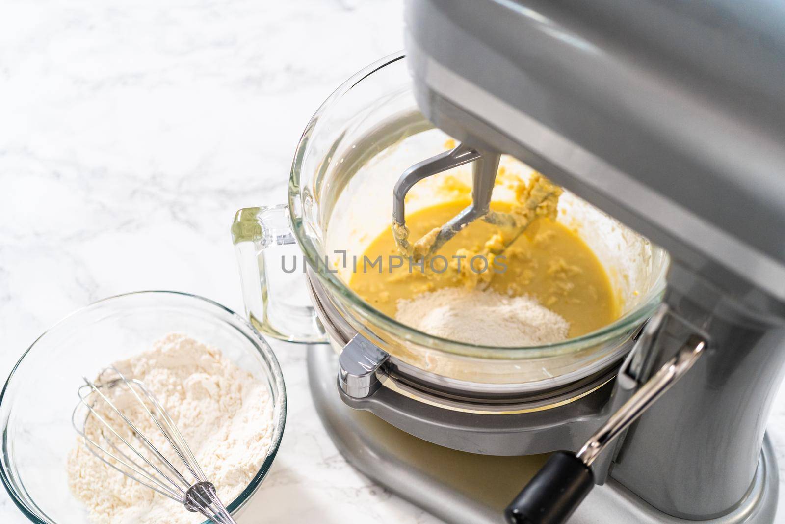 Mixing ingredients in kitchen mixer to bake mini Easter bread kulich.