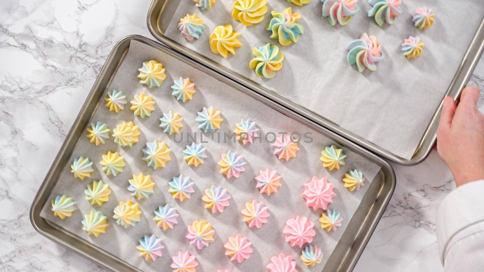 Step by step. Flat lay. Freshly baked unicorn meringue cookies on a baking sheet with a parchment paper.