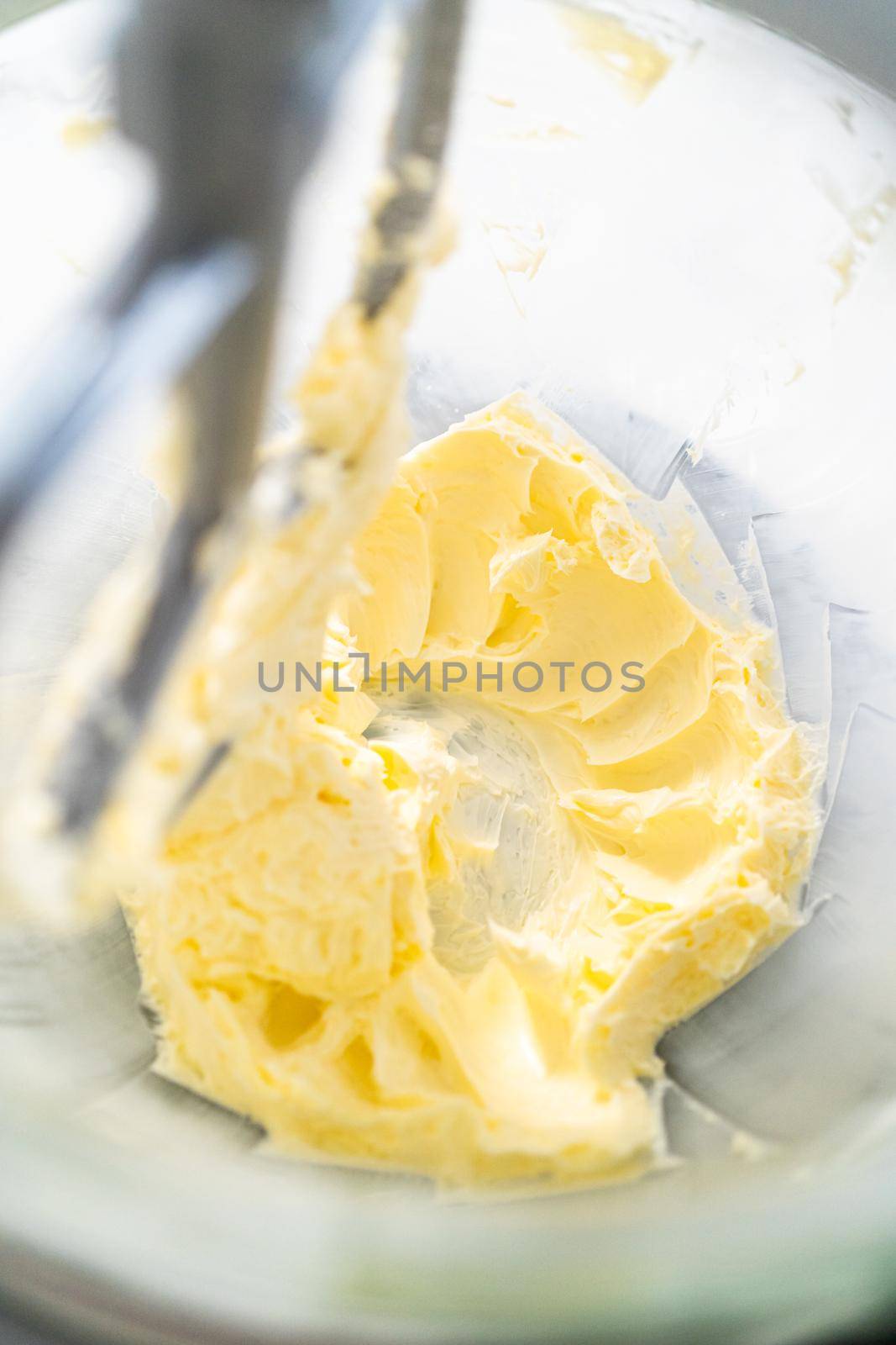 Mixing ingredients in kitchen electric mixer to make lemon buttercream frosting.