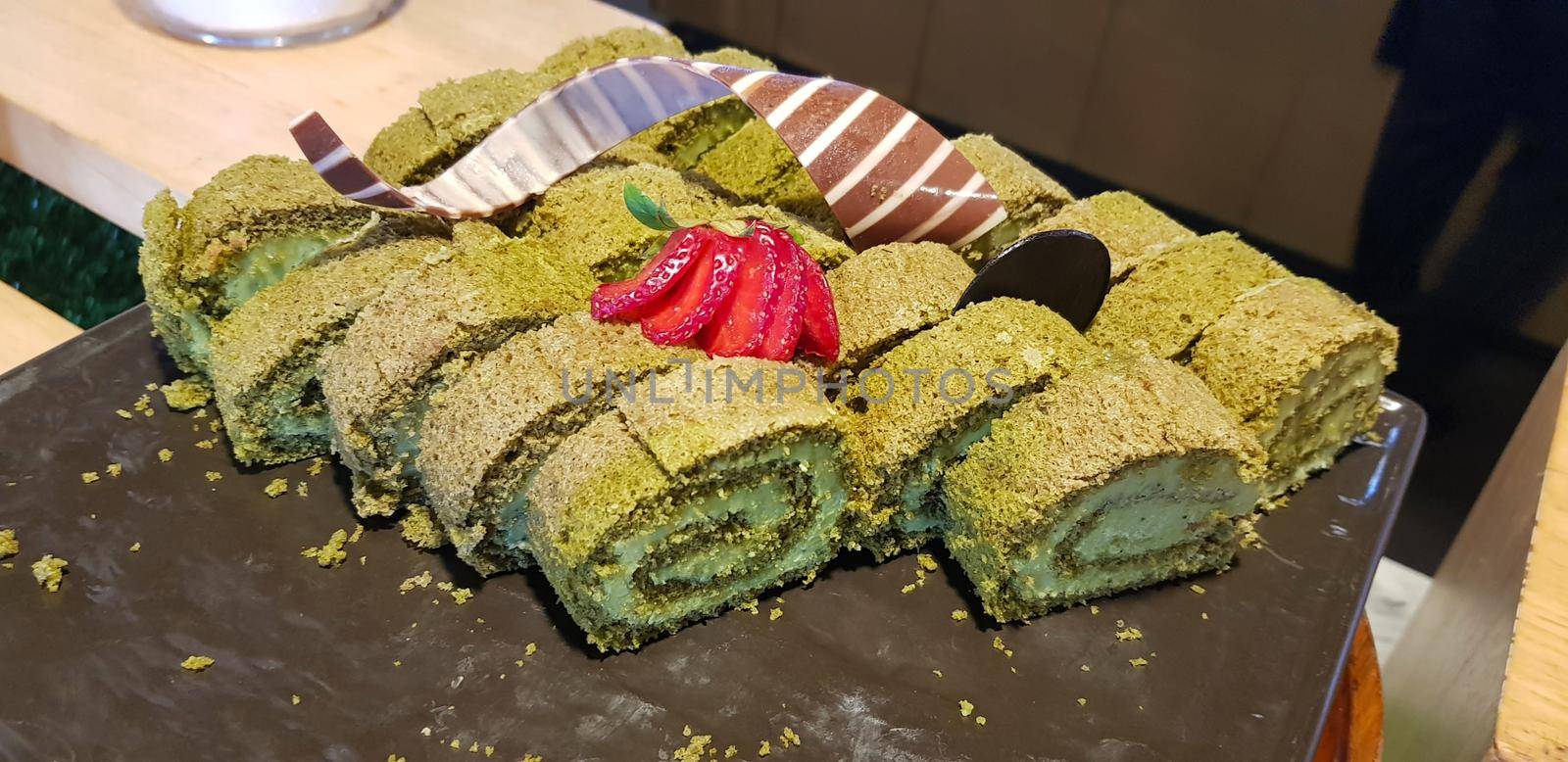 Sponge roll cake with strawberry and chocolate slice and pistachio, food photography concept in fancy restaurant