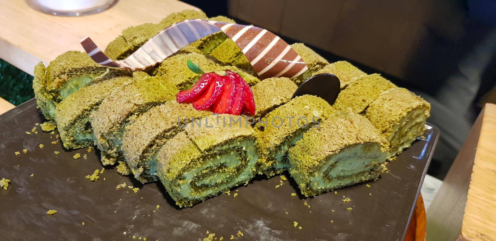 Sponge roll cake with strawberry and chocolate slice and pistachio, food photography concept in fancy restaurant